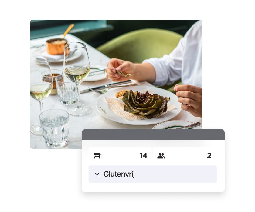 Een halve artisjok en een glas witte wijn op een gedekte tafel, afgebeeld op een keukenscherm voor horecaondernemers