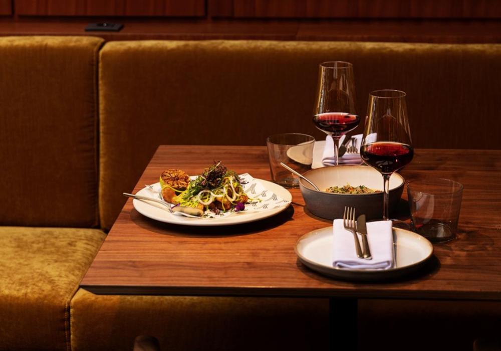 Tafel gedekt voor twee met wijnglazen en een gerecht